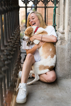 Sexy young woman at home playing with her dog