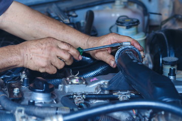 Engine repair,Mechanic working in a car under the hood,Engine repair service station.