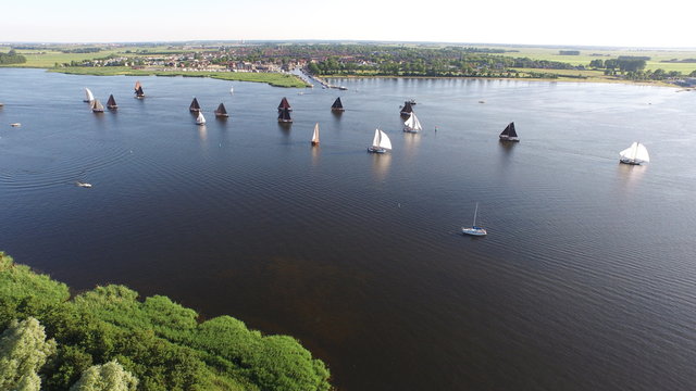 Typical Dutch botters ships with on the background fishers village Spakenburg