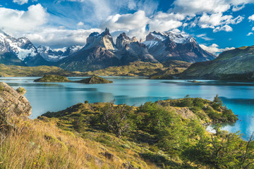 Blue lake on a snowy mountains background and cloudy sky Torres del paine - obrazy, fototapety, plakaty
