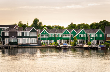 Fototapeta premium Traditional Wooden Houses along a Canal in the Netherlands at Sunset