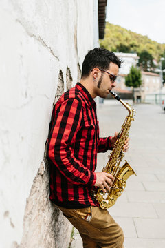 Side view of young musician playing saxophone
