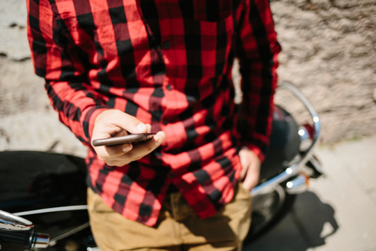 Man surfing smartphone on motorbike