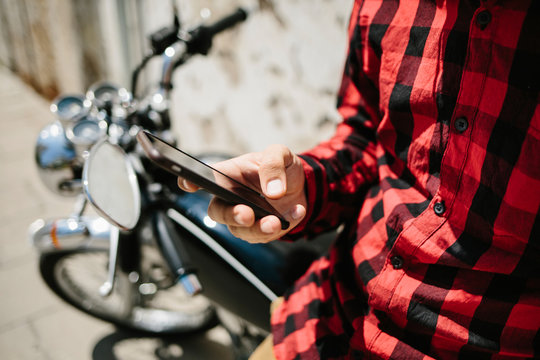 Man surfing smartphone on motorbike