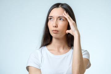 Fototapeta premium Young pretty brunette girl touching her head