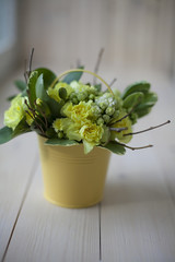 Beauty colored floral bouquet for romantic lovers on wooden board. Wedding gift for bridal. Mix flowers. A symmetrical round bouquet of yellow flowers, greenery and branches is on a wooden surface and
