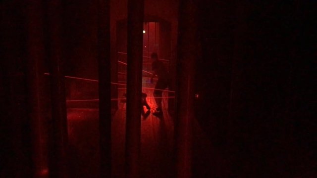 Kinder weichen in einer Laser Parkour Arena Laserstrahlen aus 