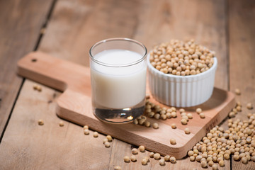 Soy milk or soya milk and soy beans in spoon on wooden table.