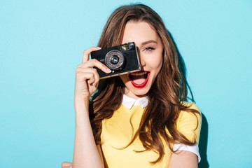 Portrait of a smiling pretty girl in dress taking photo