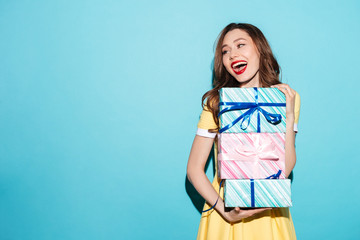 Portrait of a pretty girl holding stack of gift boxes