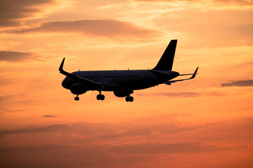 Airplane landing at sunset