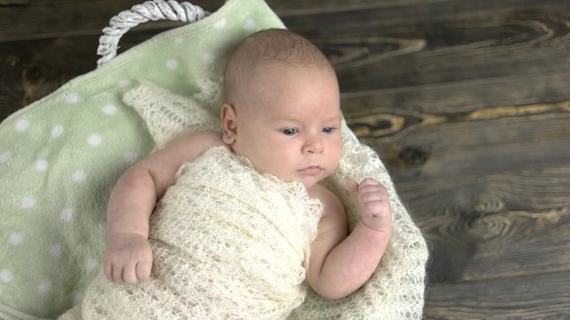 Caucasian baby, basket with bow. Legs of a small child.