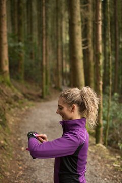 Woman using smart watch in the forest