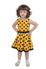 A little charming girl in a bright yellow dress, stares forward with an important air, hands on her hips