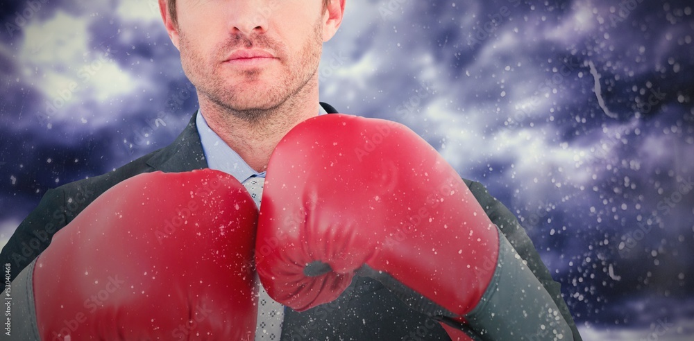 Wall mural Composite image of businessman with boxing gloves