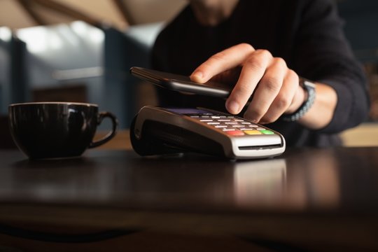 Man paying bill through smartphone using NFC technology