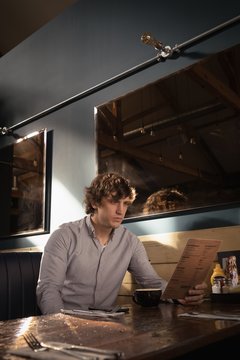 Man looking at menu card