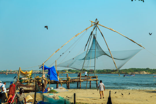 Fishermen are throwing  nets in Fort Kochi.