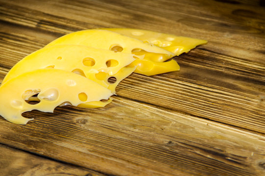 Sliced swiss cheese on wooden table