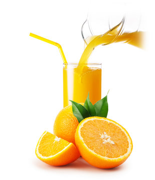 Orange juice pouring into a glass and oranges
