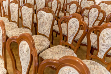 Rows of wooden chairs with fabric upholstery
