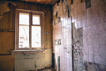 Room in an abandoned building, peeling walls with fallen tiles