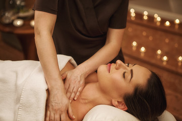 Fototapeta na wymiar Beautiful woman relaxing receiving body massage at spa center