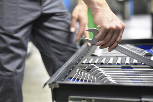 Mechanic taking jaw spanner from tool box