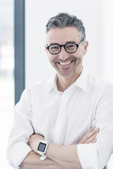 Portrait of smiling businessman wearing smartwatch and glasses
