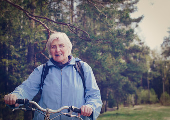 happy active senior riding bike in nature