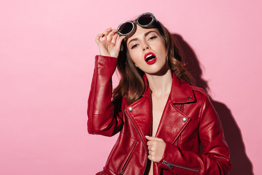 Pretty stylish girl in sunglasses and leather jacket posing