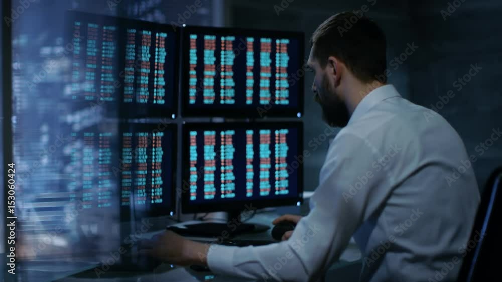 Poster Late at Night Trader Reads Numbers on His Multiple Displays with Stock Information on Them. In Background Big City Window View. Shot on RED EPIC-W 8K Helium Cinema Camera.