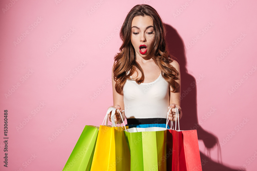 Canvas Prints Portrait of an excited woman looking at colorful shopping bags