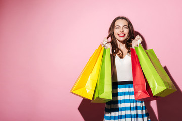 Fototapeta na wymiar Happy girl carrying colorful shopping bags