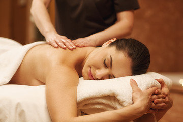 Fototapeta na wymiar Beautiful woman relaxing receiving body massage at spa center