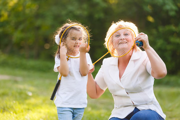 Fototapeta premium Mother and daughter playing tennis, portrait