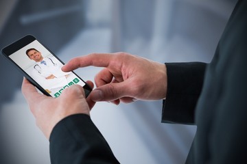 Composite image of businessman using smart phone