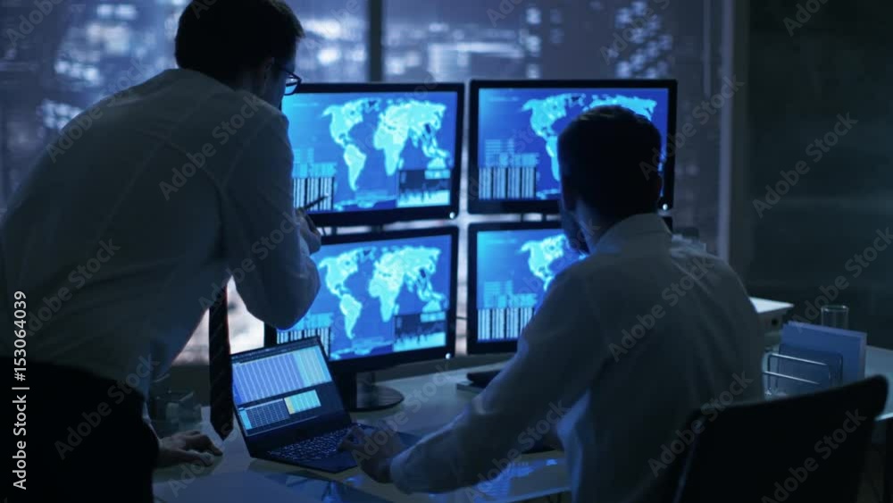 Poster Late at Night in Office Building Security Service Men Have Discussion while  Attentively Observing Monitors with Location Sensitive Information Shown on Them.  Shot on RED EPIC-W 8K Helium Camera