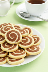 Obraz na płótnie Canvas Vanilla and Chocolate Spiral Pinwheel Cookies with Tea