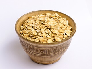 Oat flakes in a bowl on a white background