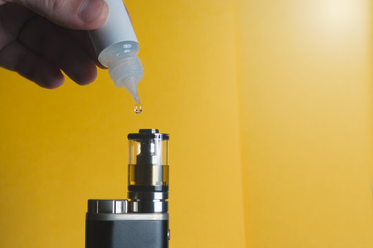 Close-up of filling e-cigarette atomizer with e-liquid