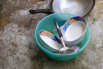 washing dishes in sink plastic green on the cement floor