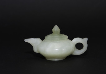 Jade green vintage teapot against a black background