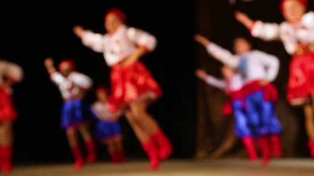 Defocused silhouettes of children dancing cheerfully on stage. Slow motion hd video footage.