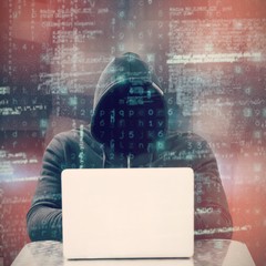Composite image of focused male hacker using laptop 