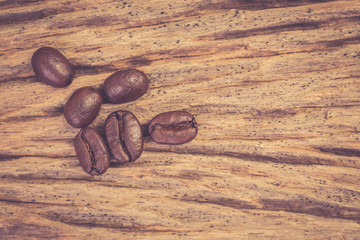 Roasted coffee beans on wood texture background. vintage color effected