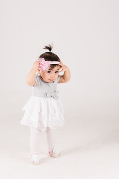 Little girl holding her crawn and wearing pink shirt and white tutu