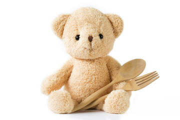 Bear doll sitting with wooden spoon and fork on white background isolated.