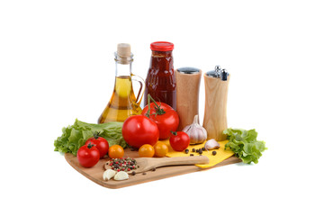 Still life of red and yellow tomatoes, bottle of tomato sauce and olive oil on white background.