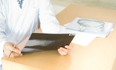 Close up of doctor holding x-ray or film image.
